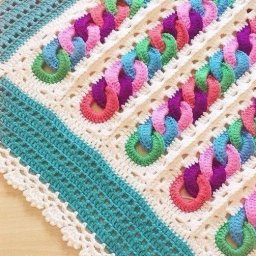Необычный детский плед крючком с узором из разноцветных колечек