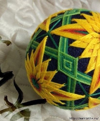 Темари или искусство вышивки на шарах: роскошный желтый цветок на темном фоне