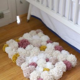 ​Тёплый коврик из крупных помпонов