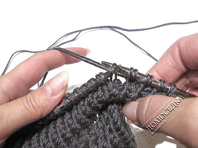 Оригинальный вязаный шарф выполнен спицами текстурной вязкой имитирующей складки.