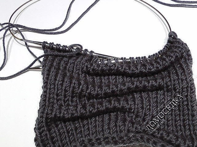 Оригинальный вязаный шарф выполнен спицами текстурной вязкой имитирующей складки.